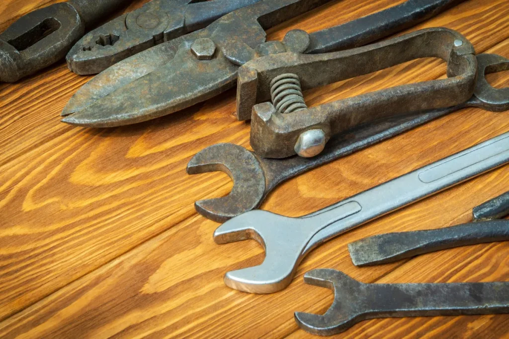 Old tools stacked on vintage wood, ready for sewer repair work related to foul odors.